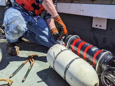 Toby Dewhurst of Kelson Marine adjusts load cell to measure drag on seaweed farm at St. Gelais